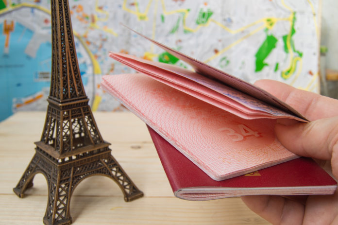 Passport in hand for trip, travel, journey. On map background