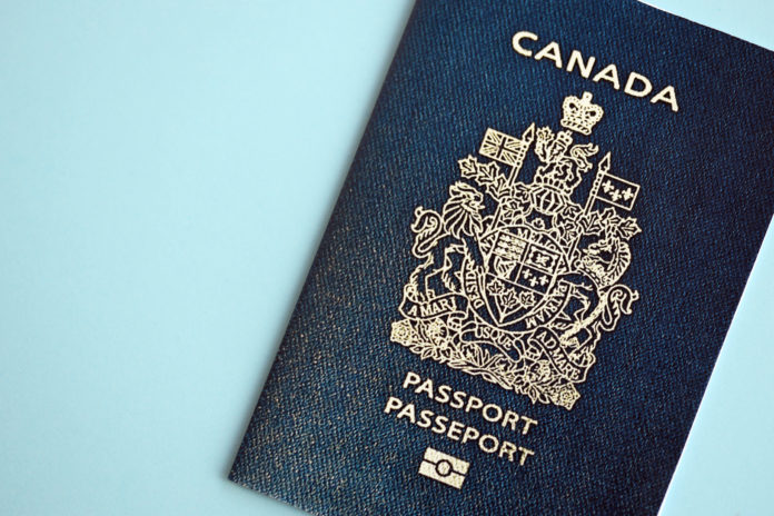 Canadian passport on blue background close up