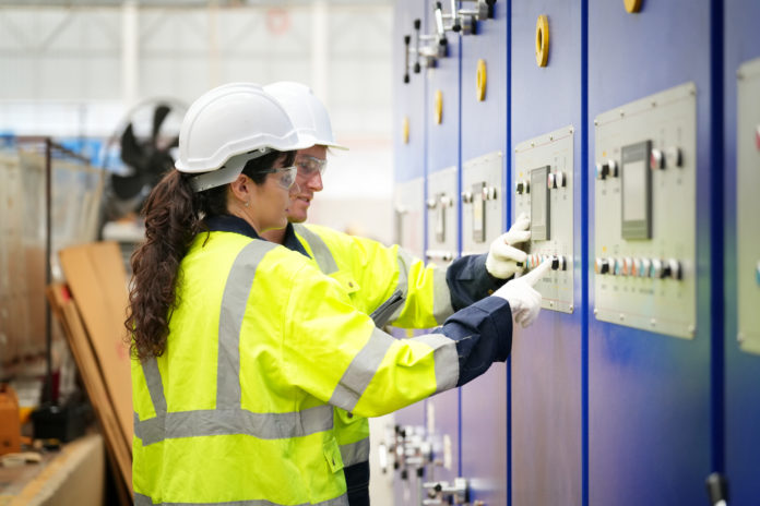 Industrial factory workers working in metal manufacturing industry.