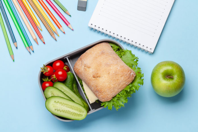 Lunch box with sandwich, vegetables and juice