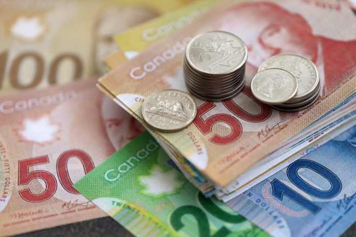 Canadian dollar money bills and cent coins pile on table. Canada coins on banknotes of CAD currency