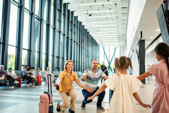 Parents greeting daughters at airport during family reunion