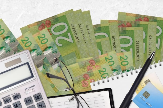 20 Canadian dollars bills and calculator with glasses and pen. Tax payment concept or investment solutions. Financial planning or accountant paperwork