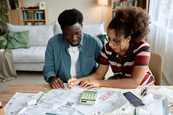 Adult Black Couple Reviewing Invoices and Bills Together at Home